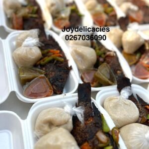 Banku and Spicy Charcoal Grilled Tilapia, 2 balls of banku, 2 types of chilli sauces, chopped veggies